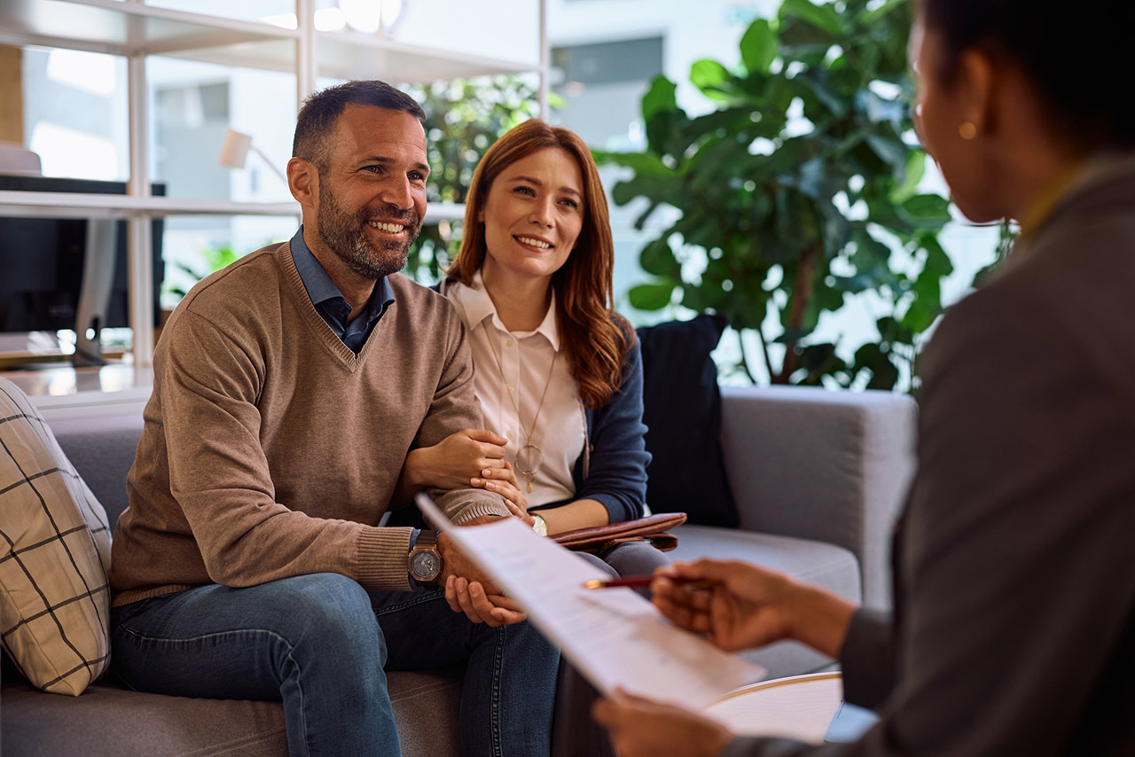 Happy couple having consultations with real estate agent in the office